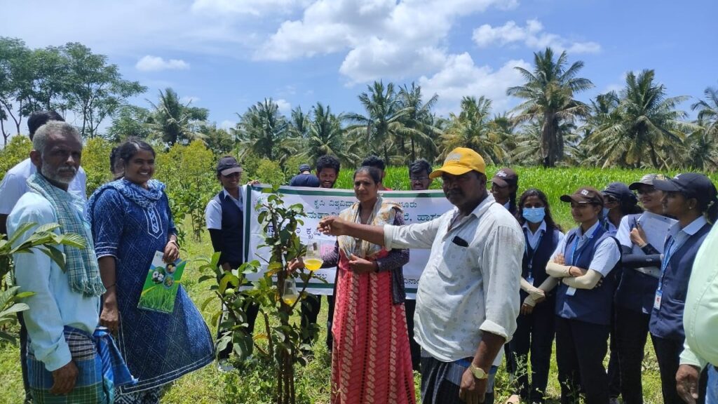Students of Hassan Krishi Mahavidyalaya engaging with farmers at a camp on how to protect crops from insects.