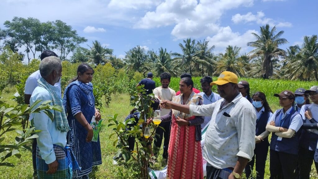 Students of Hassan Krishi Mahavidyalaya engaging with farmers at a camp on how to protect crops from insects.