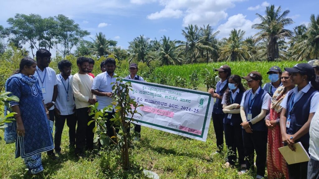 Students of Hassan Krishi Mahavidyalaya engaging with farmers at a camp on how to protect crops from insects.